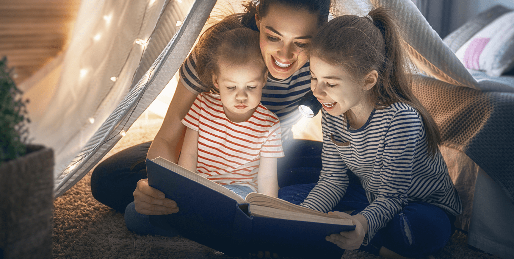 Family smiling and reading book